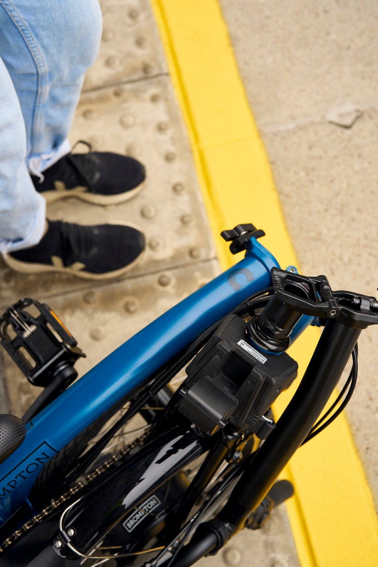 Brompton Electric C Line folded by a person working on laptop